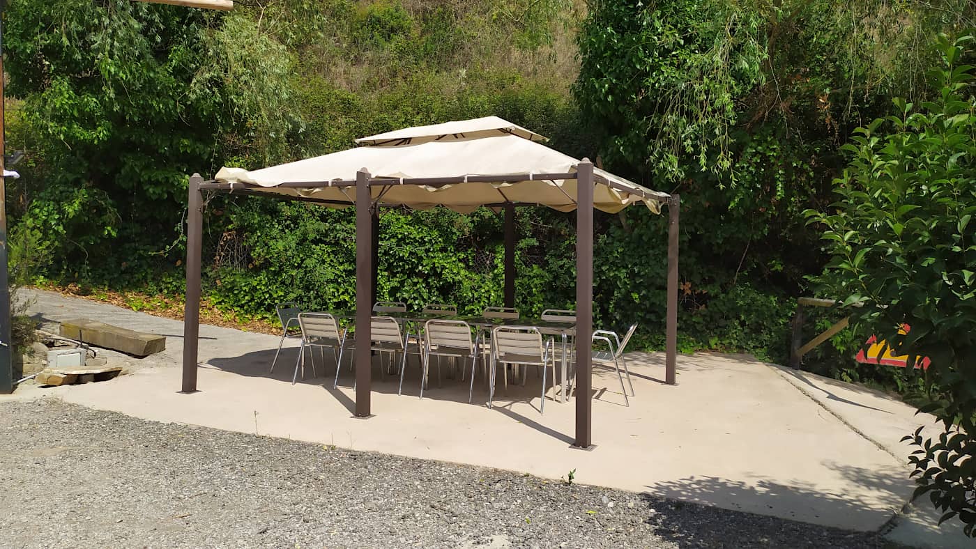 Pérgola con mesas y sillas para comer y cenar al aire libre